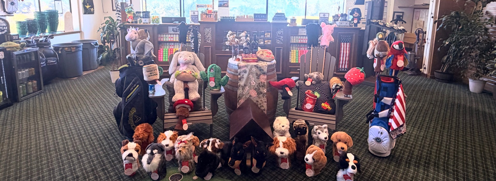 Stuffed animal mascots displayed on a Corona Premier putting green rug in the Pajaro Valley Golf Club Golf Shop